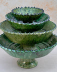 Authentic Tamegroute pottery bowl, handmade in the village of Tamegroute, southern Morocco. Every bowl is hand-thrown from local mineral-rich clay and finished with the village's signature deep green glaze. Fired in underground wood-fired kilns using centuries-old techniques, the heat creates natural variations in tone and texture across each piece. The glaze reacts organically to the kiln fire, producing distinctive emerald-to-moss tones with subtle bronze highlights. No two bowls are identical.
Perfect as
