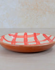 Ceramic plate with red abstract design on a white background