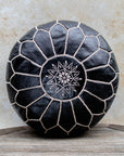 Black Moroccan leather pouf with beige stitching front view