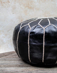Black and beige stitched pouf styled in living room