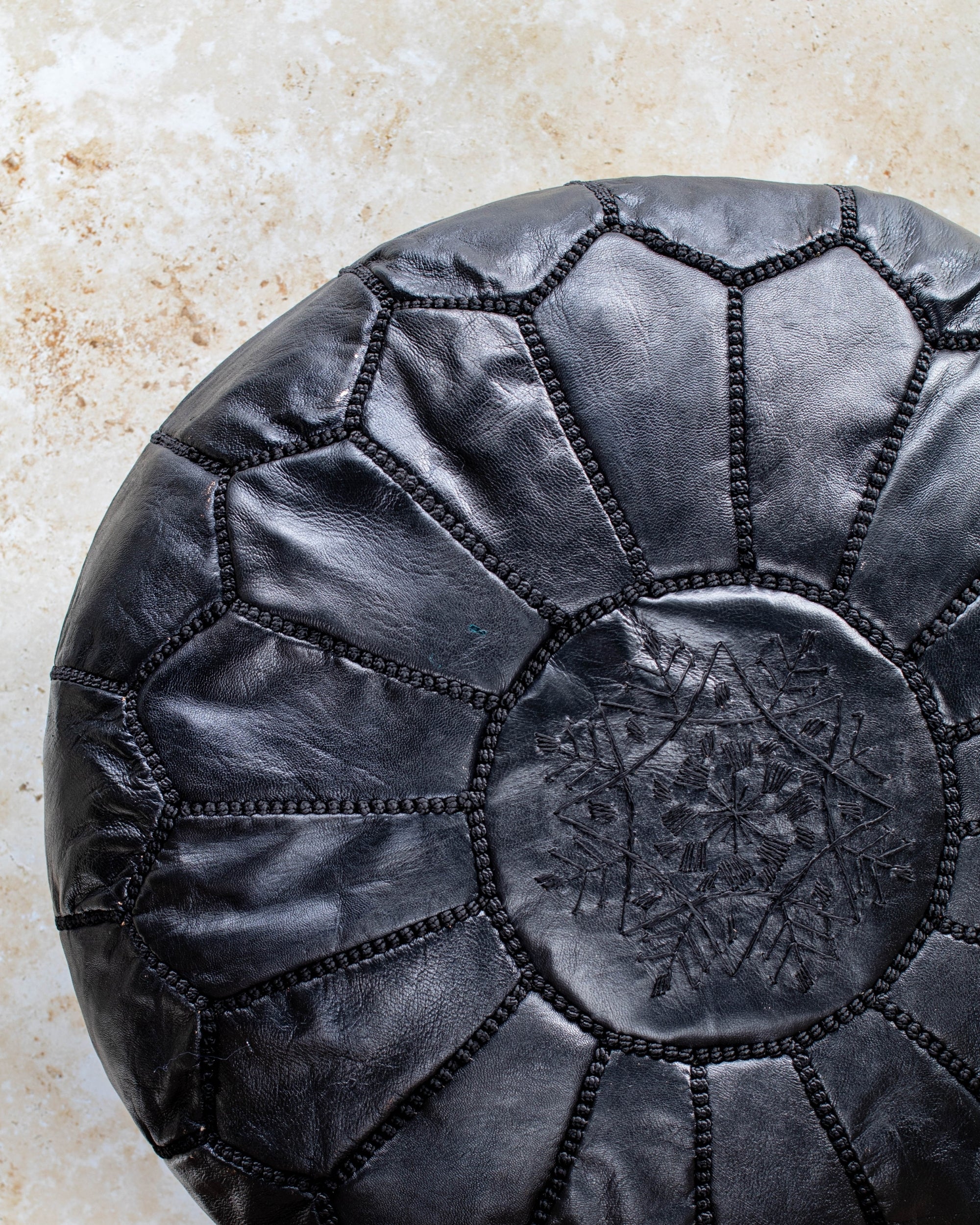 Black leather pouf – close-up of hand stitching
