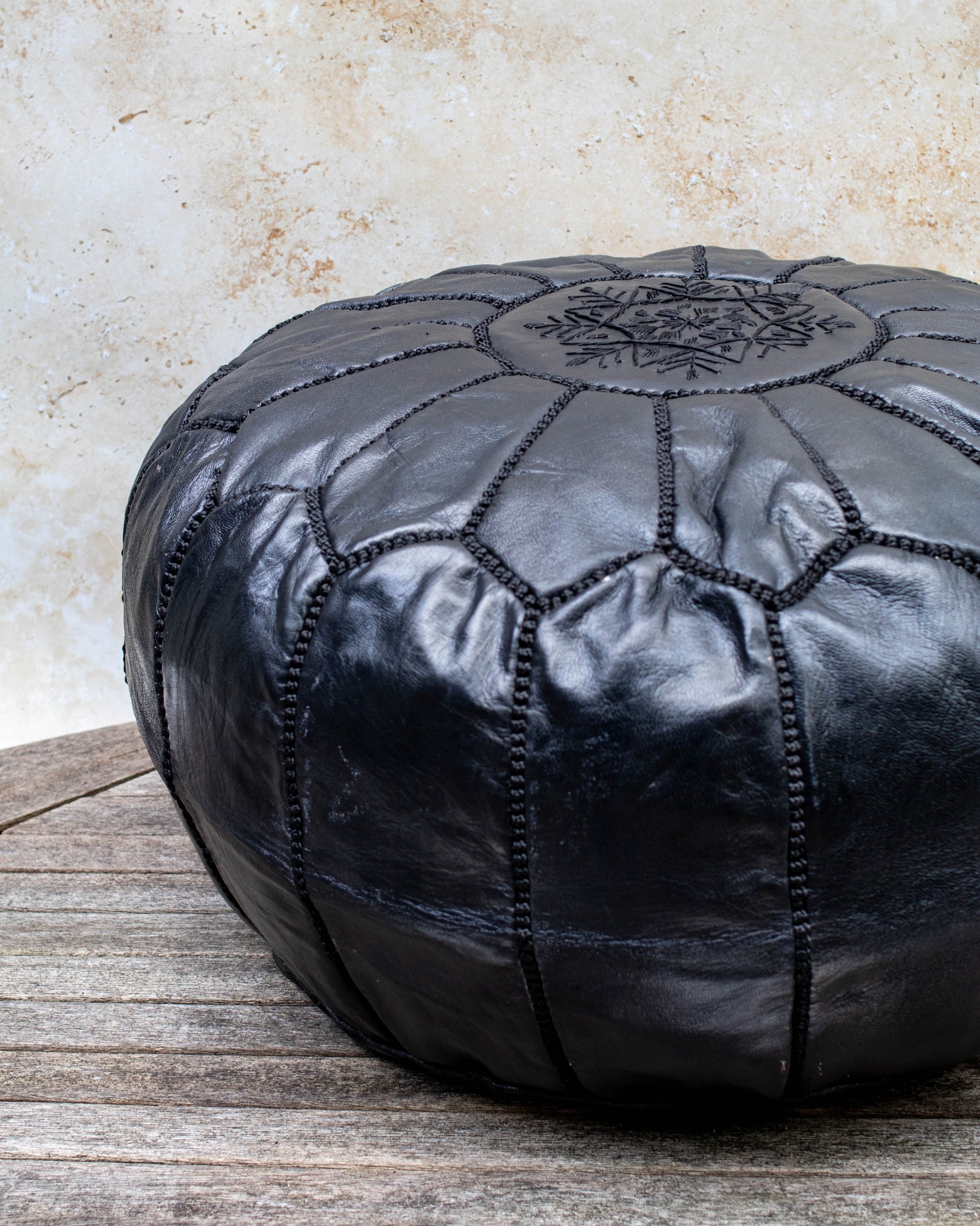 Black pouf styled in living room as ottoman