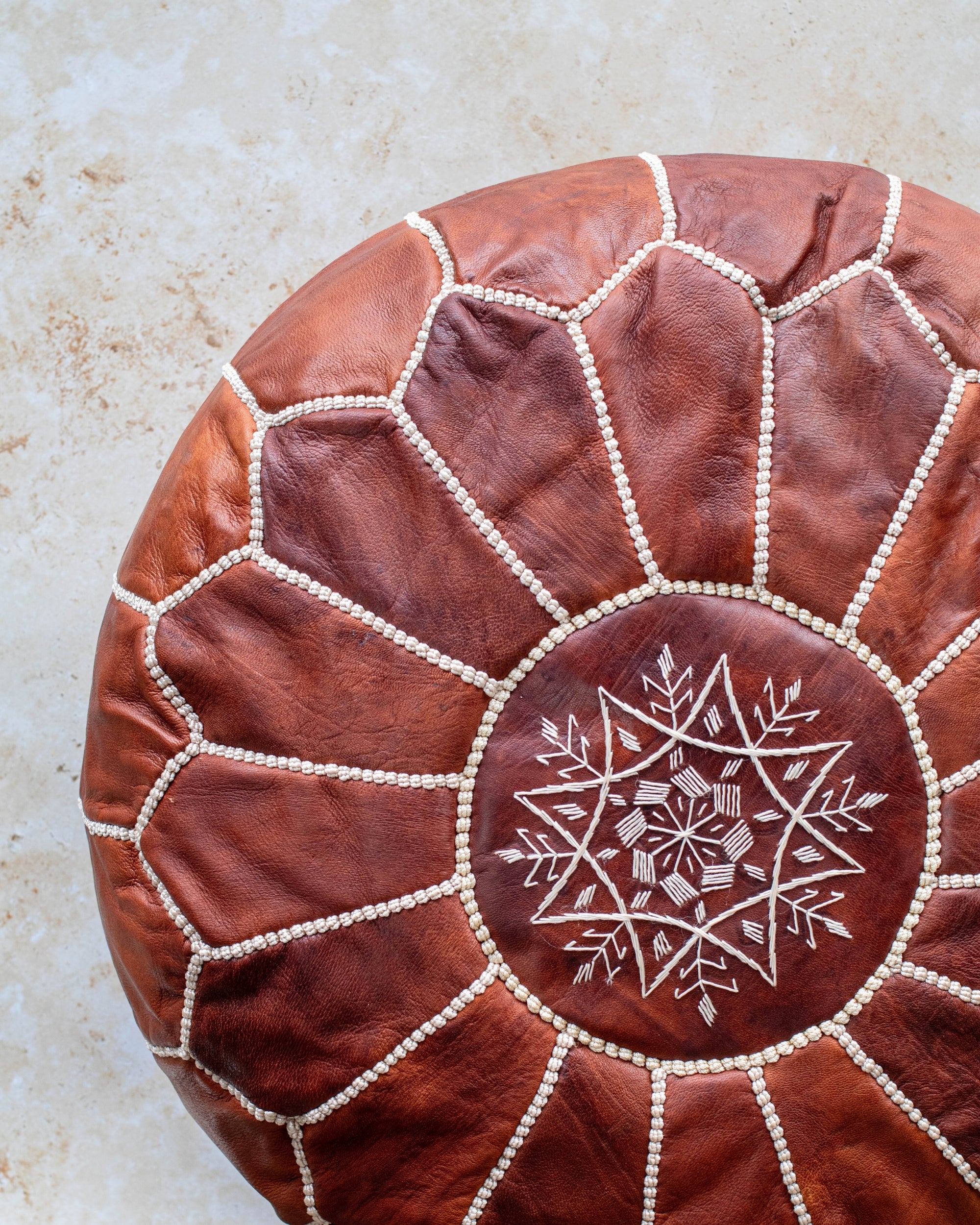 Brown leather pouf – close-up of hand stitching