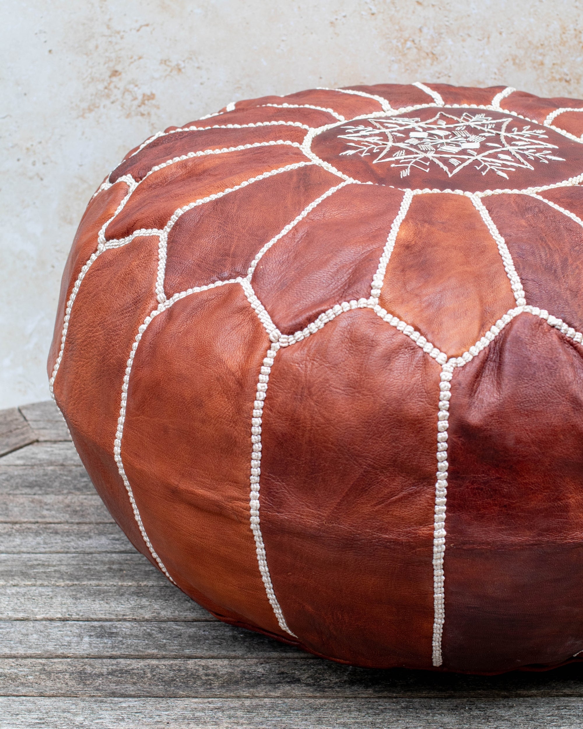 Brown pouf styled in living room as ottoman