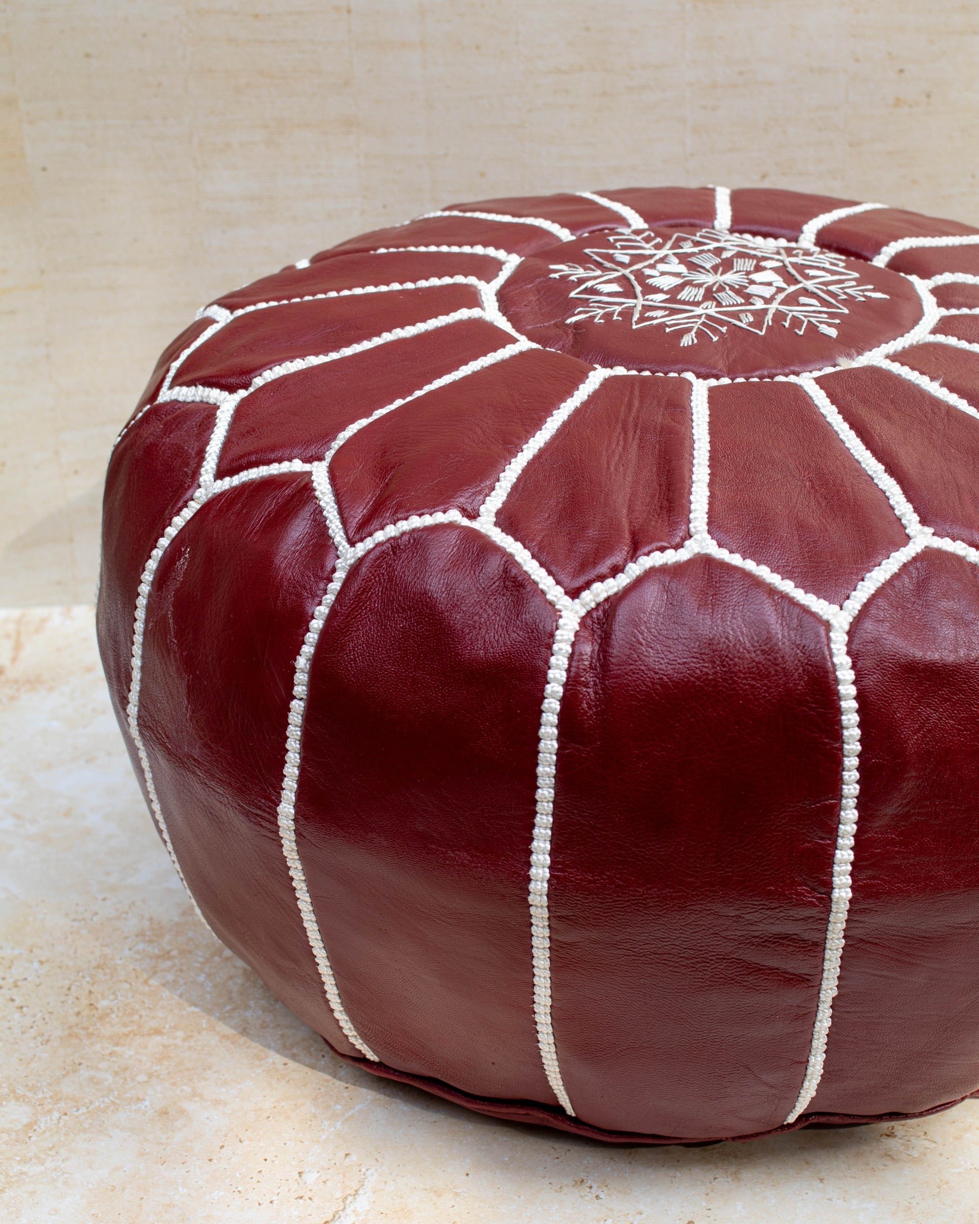 Burgundy leather pouf – hand-stitch detail close-up