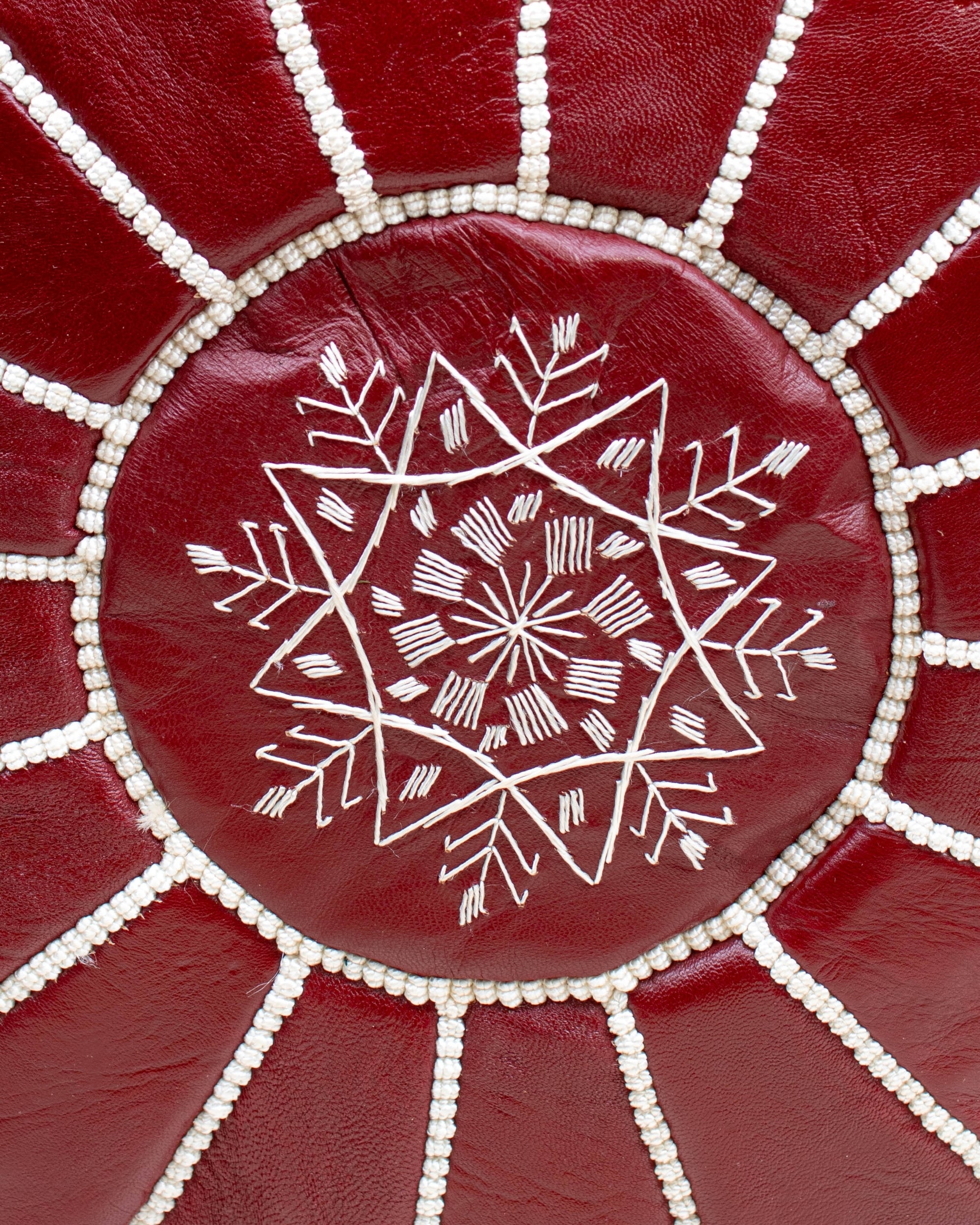 Burgundy pouf styled in living room as ottoman