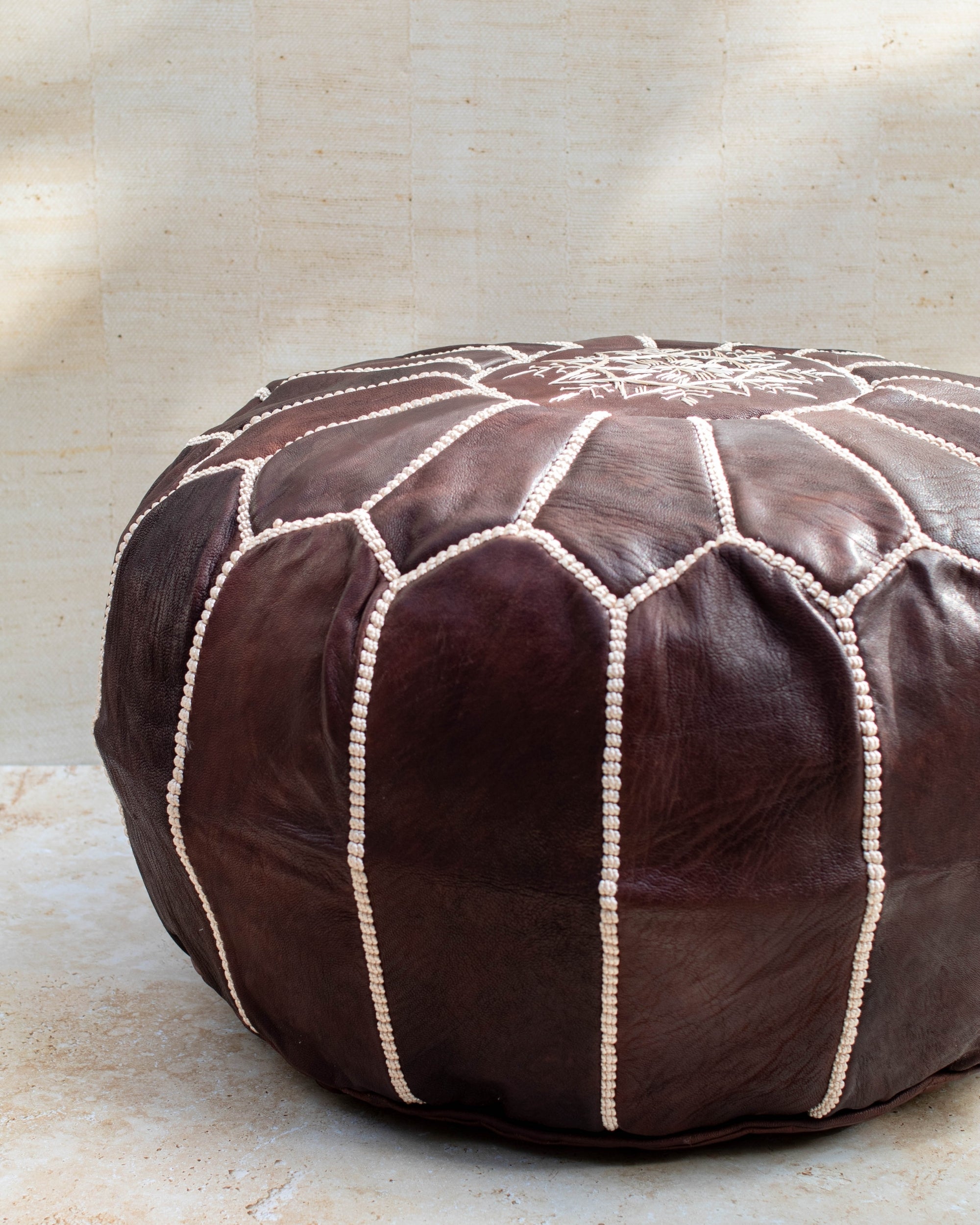 Chocolate leather pouf styled in living room