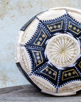Close-up of gold embroidery on black and cream leather pouf