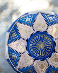 Close up of gold embroidery on blue and cream leather pouf