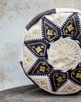 Close up of gold embroidery on brown and cream leather pouf