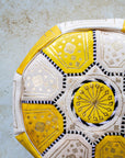 Close up of gold embroidery on yellow and cream leather pouf