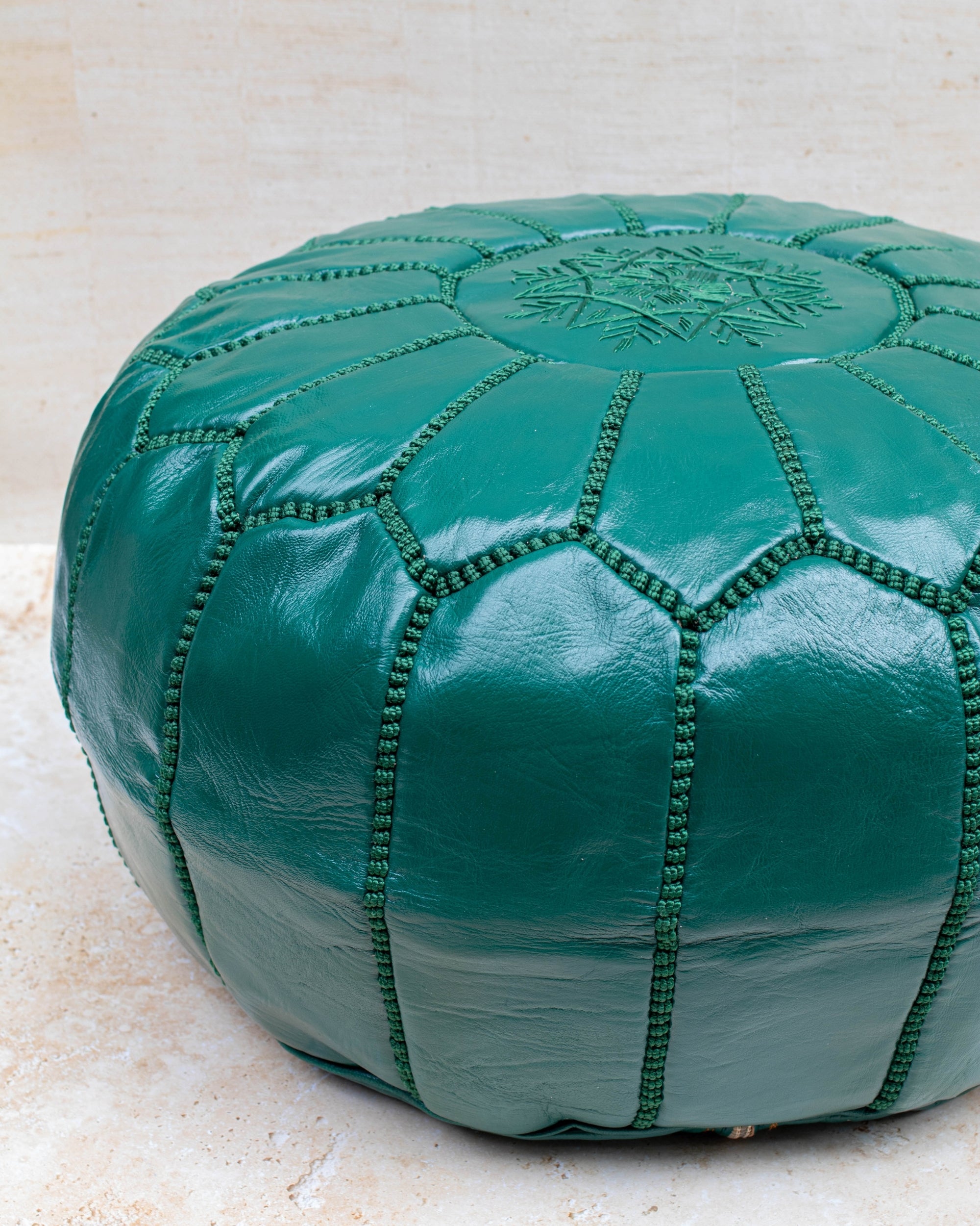 Emerald green pouf styled as ottoman in living room