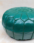 Emerald green pouf styled as ottoman in living room