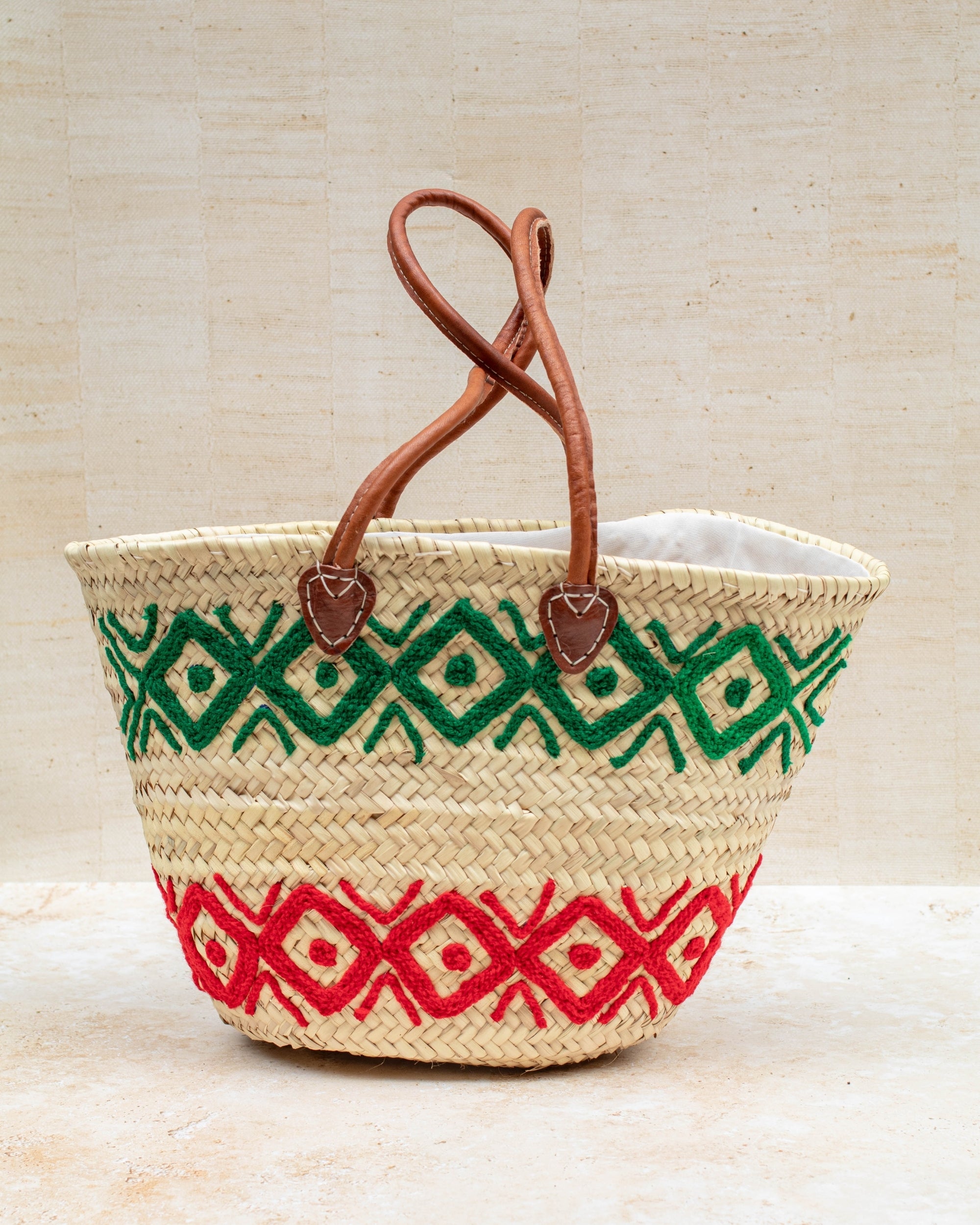 Green and red embroidered basket styled for market day