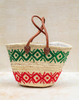 Green and red embroidered basket styled for market day