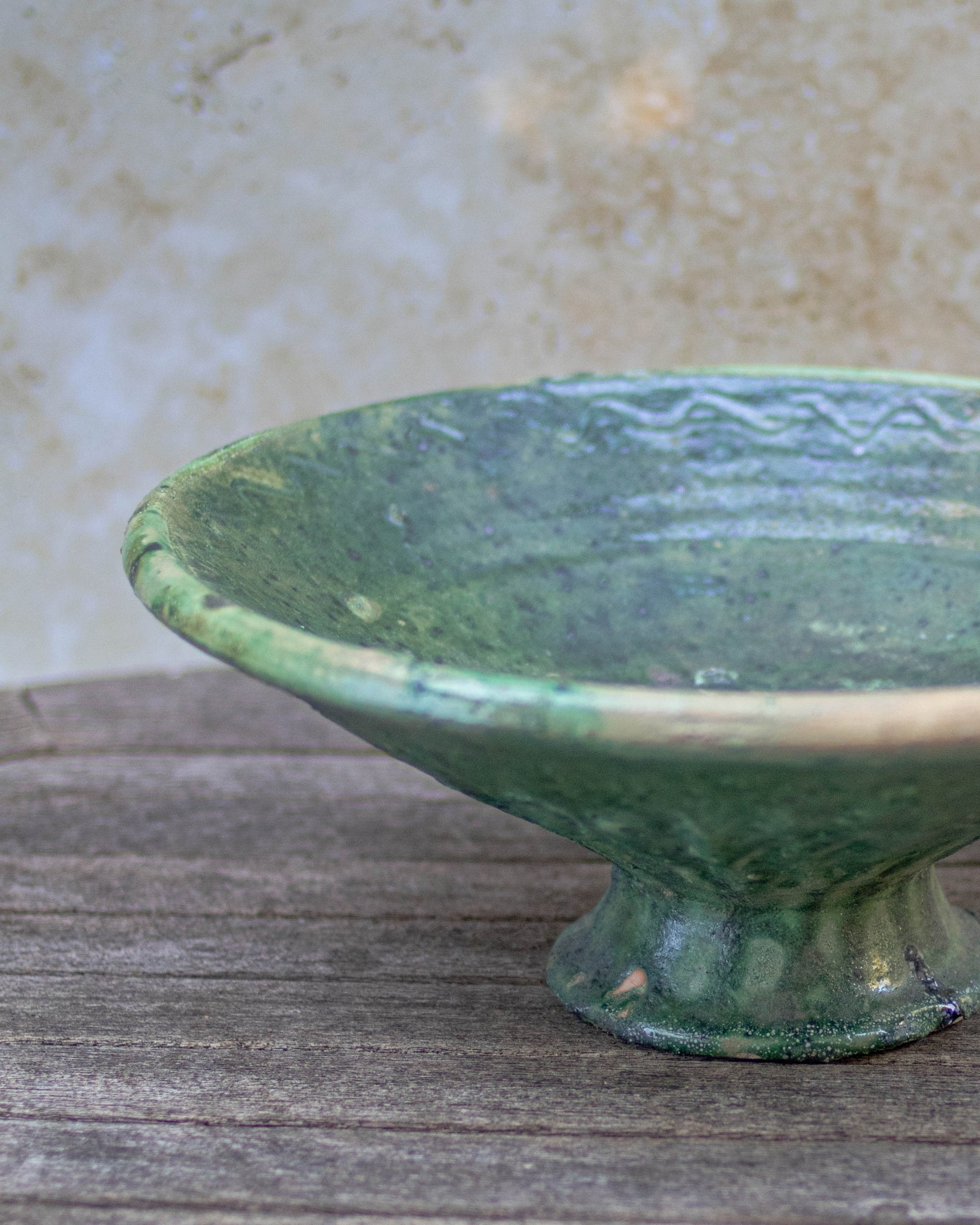 Green pedestal bowl filled with fruit — artisan Moroccan pottery