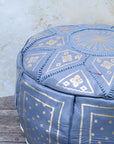 Grey and gold Moroccan pouf styled as ottoman in living room