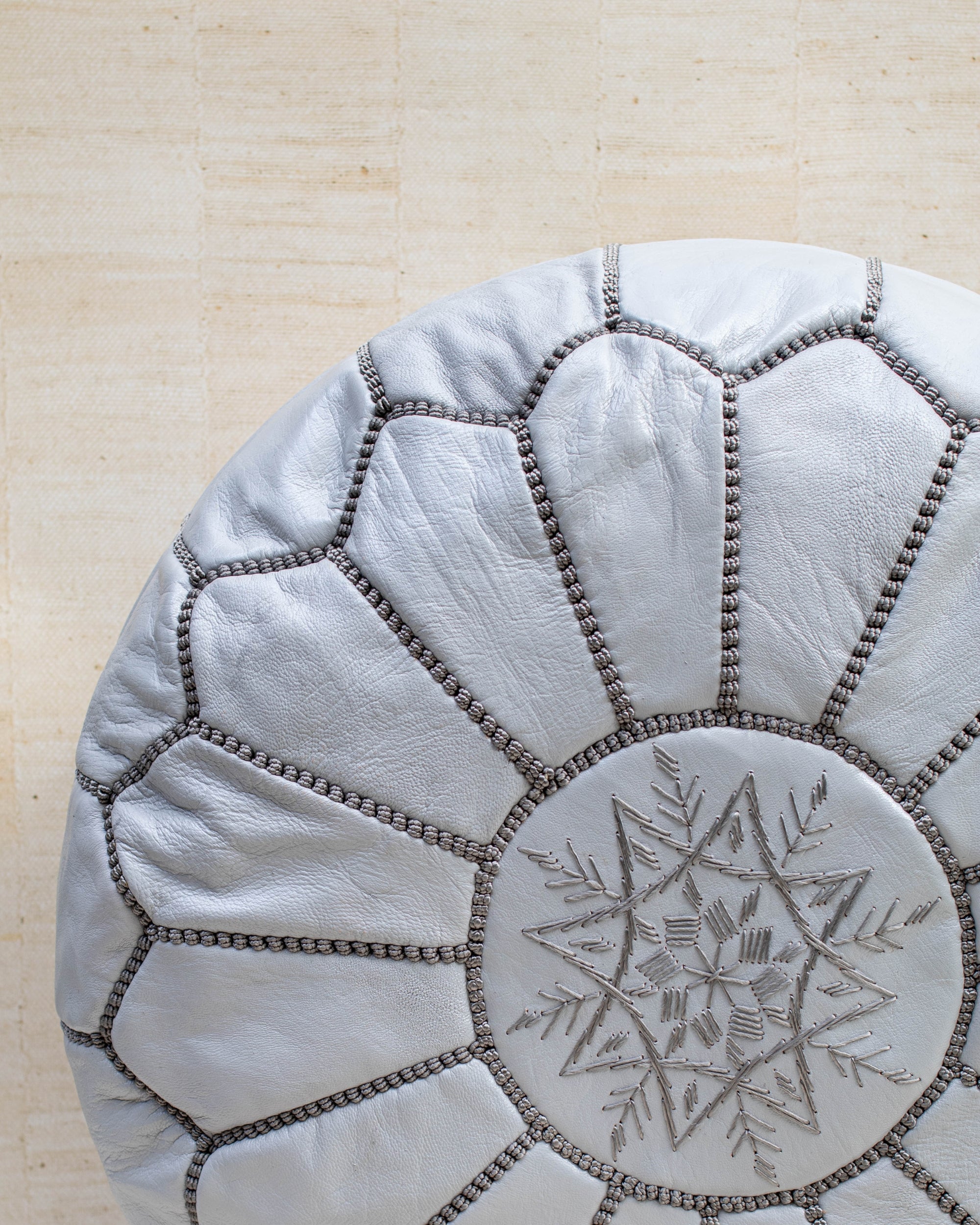 Grey leather pouf with hand-stitching – embroidery detail close-up