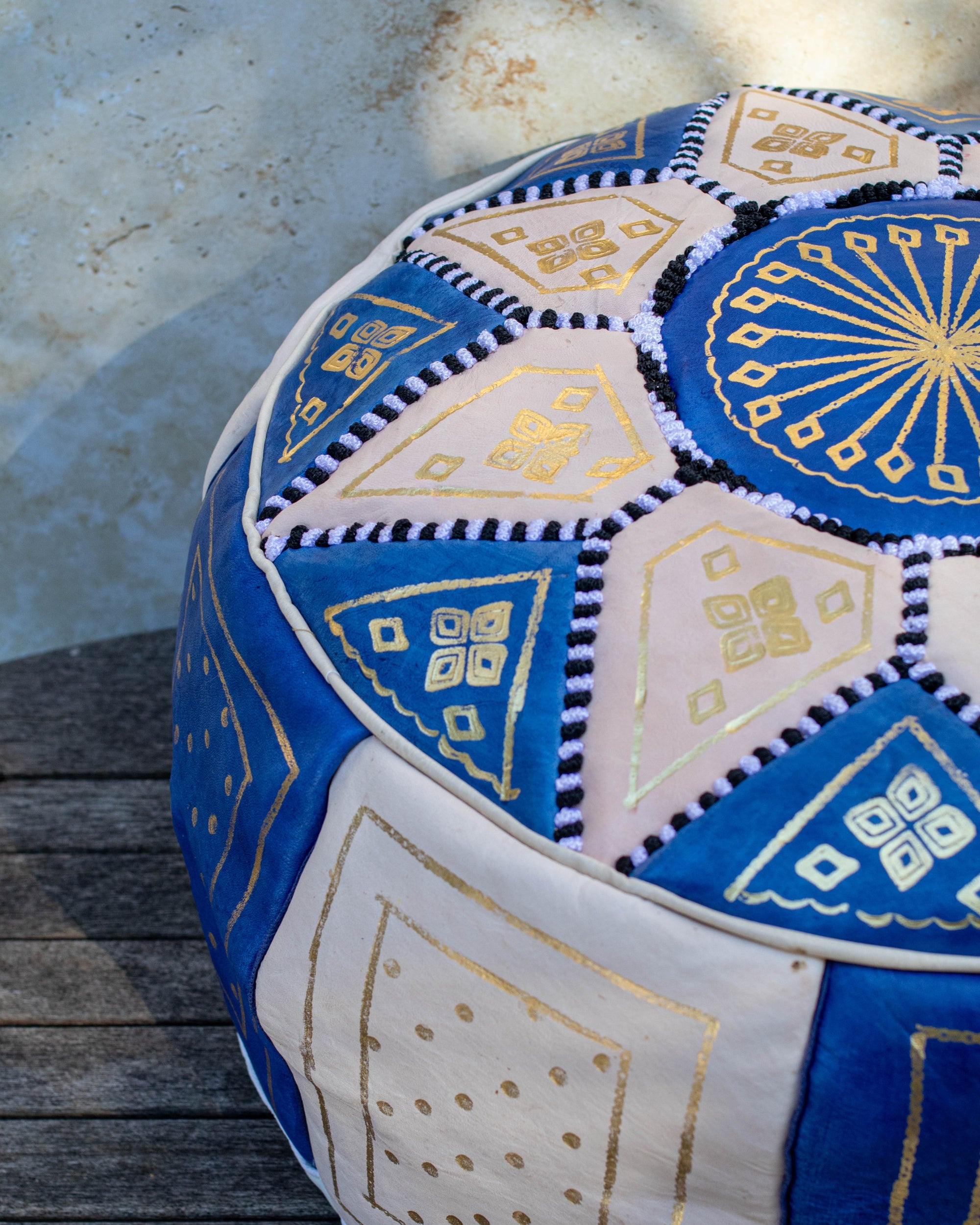 Moroccan leather pouf styled as ottoman in living room