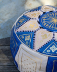 Moroccan leather pouf styled as ottoman in living room