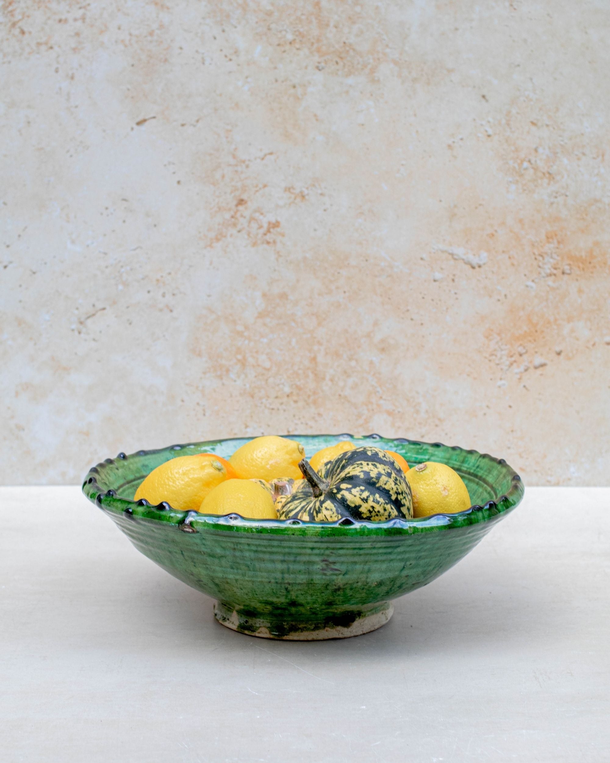 Handmade Moroccan green ceramic bowl set on neutral background