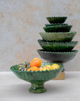 Large green bowl used as fruit bowl on wooden table