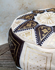Moroccan leather pouf styled as ottoman in living room
