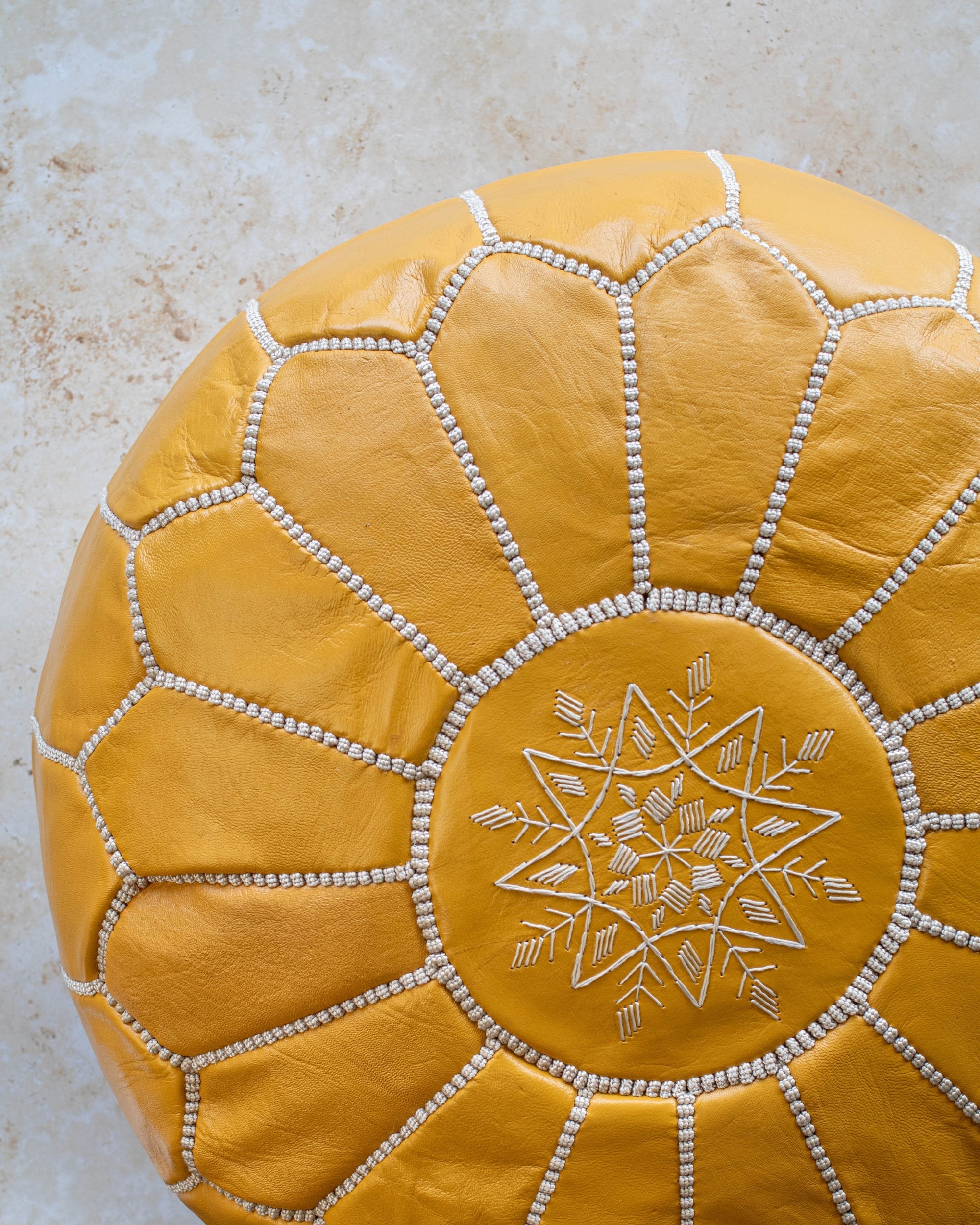 Mustard leather pouf stitching detail close up
