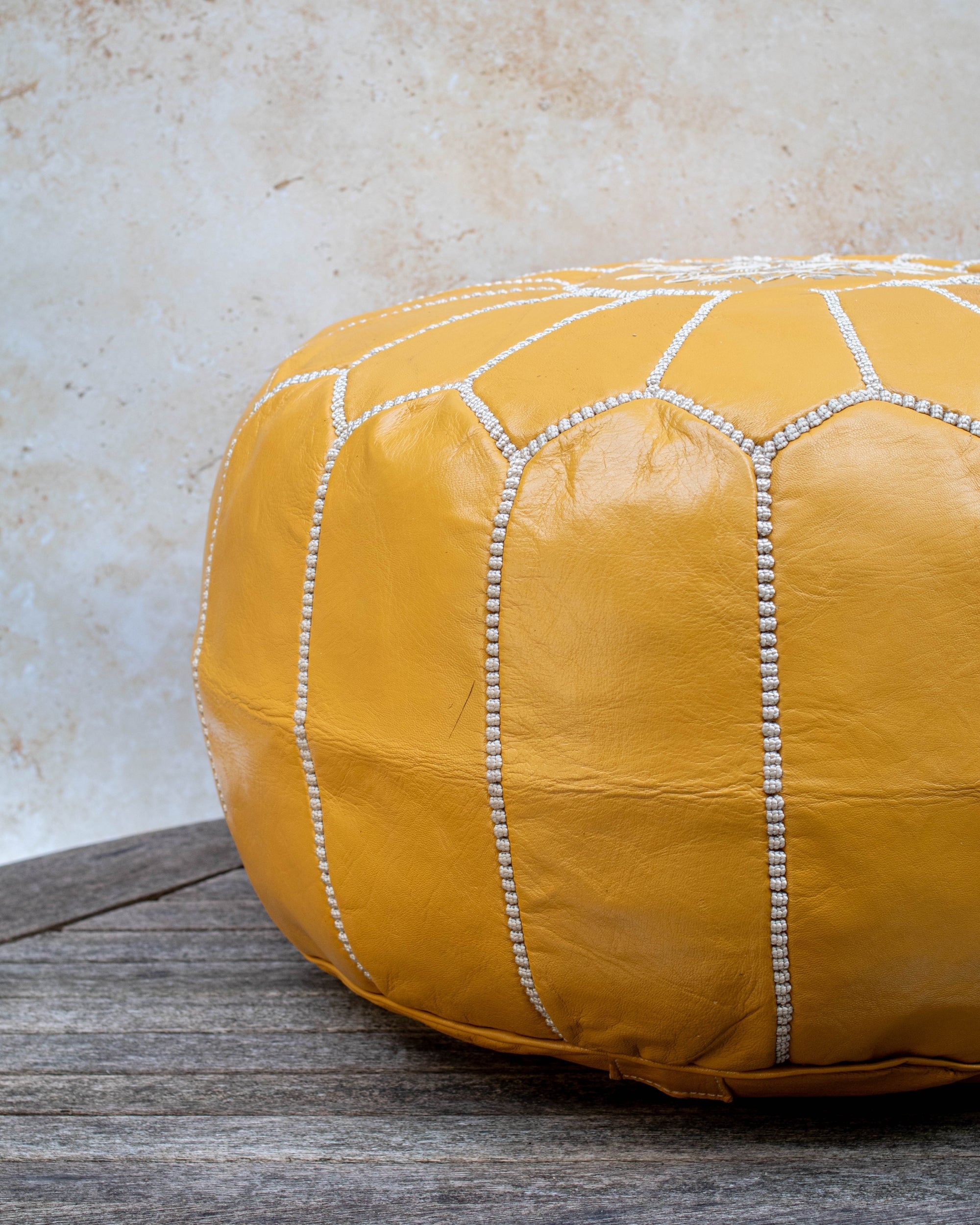 Mustard leather pouf styled in living room
