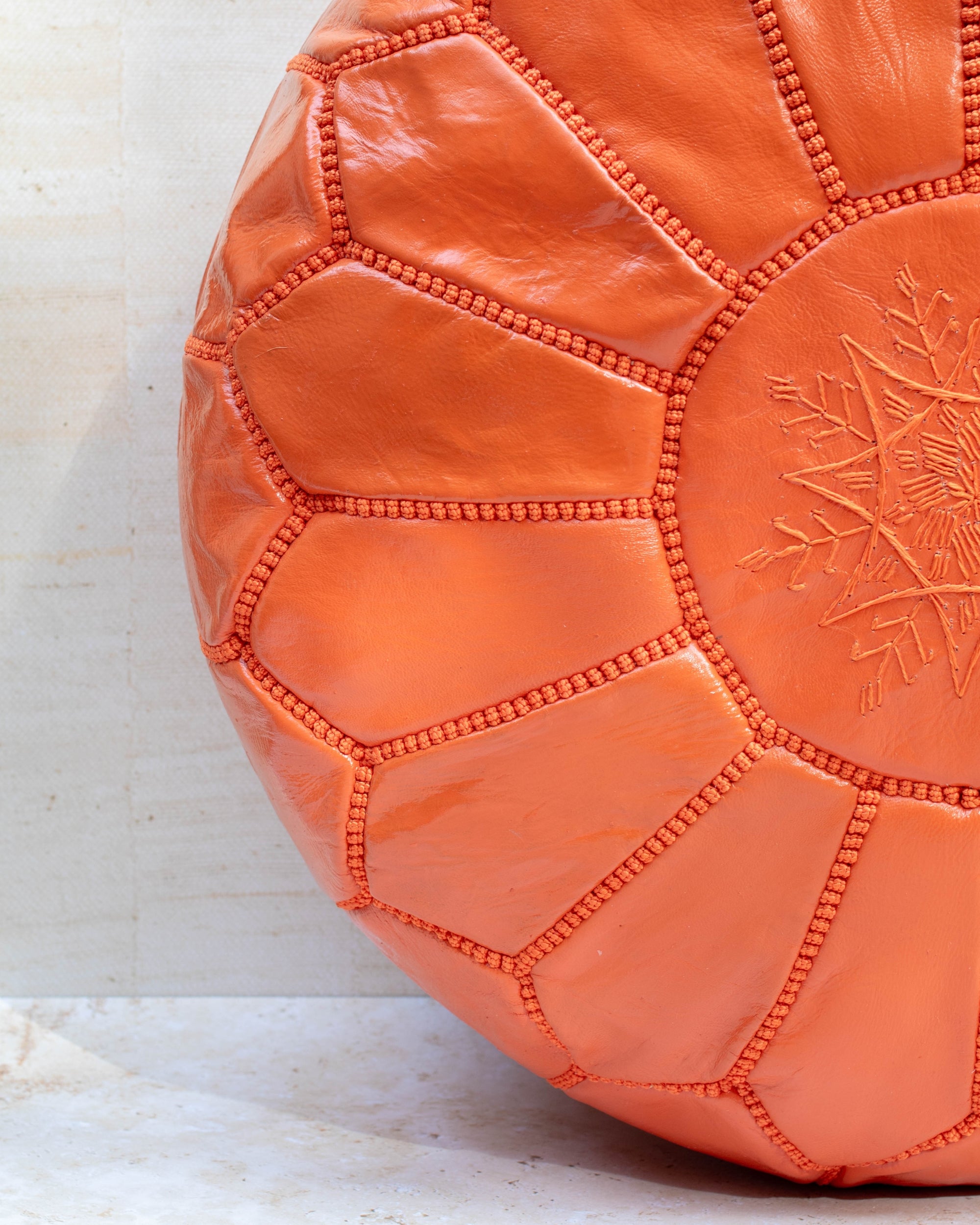Orange leather pouf with hand-stitching – embroidery detail close-up