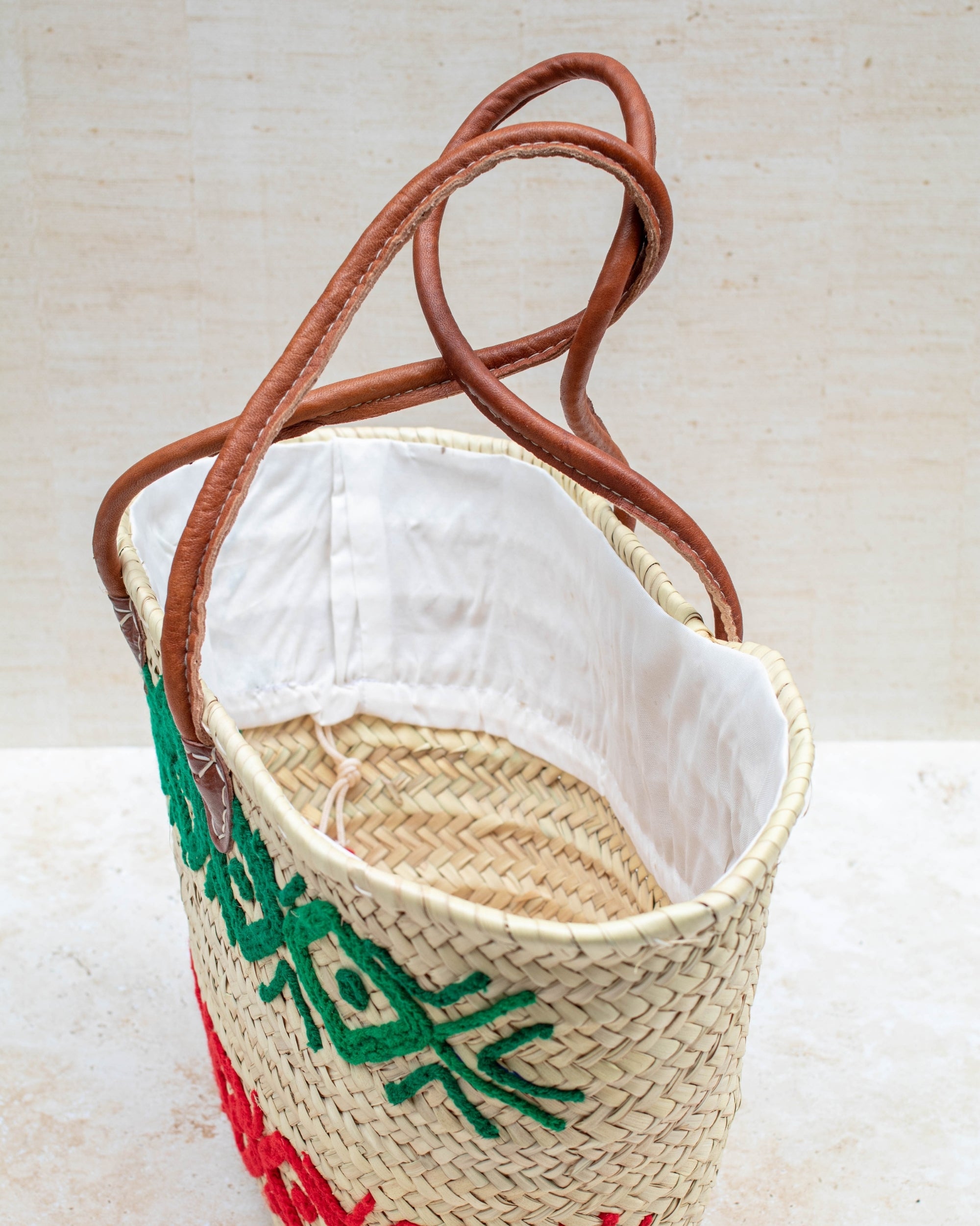 Palm leaf basket with green and red embroidery – close-up of stitching