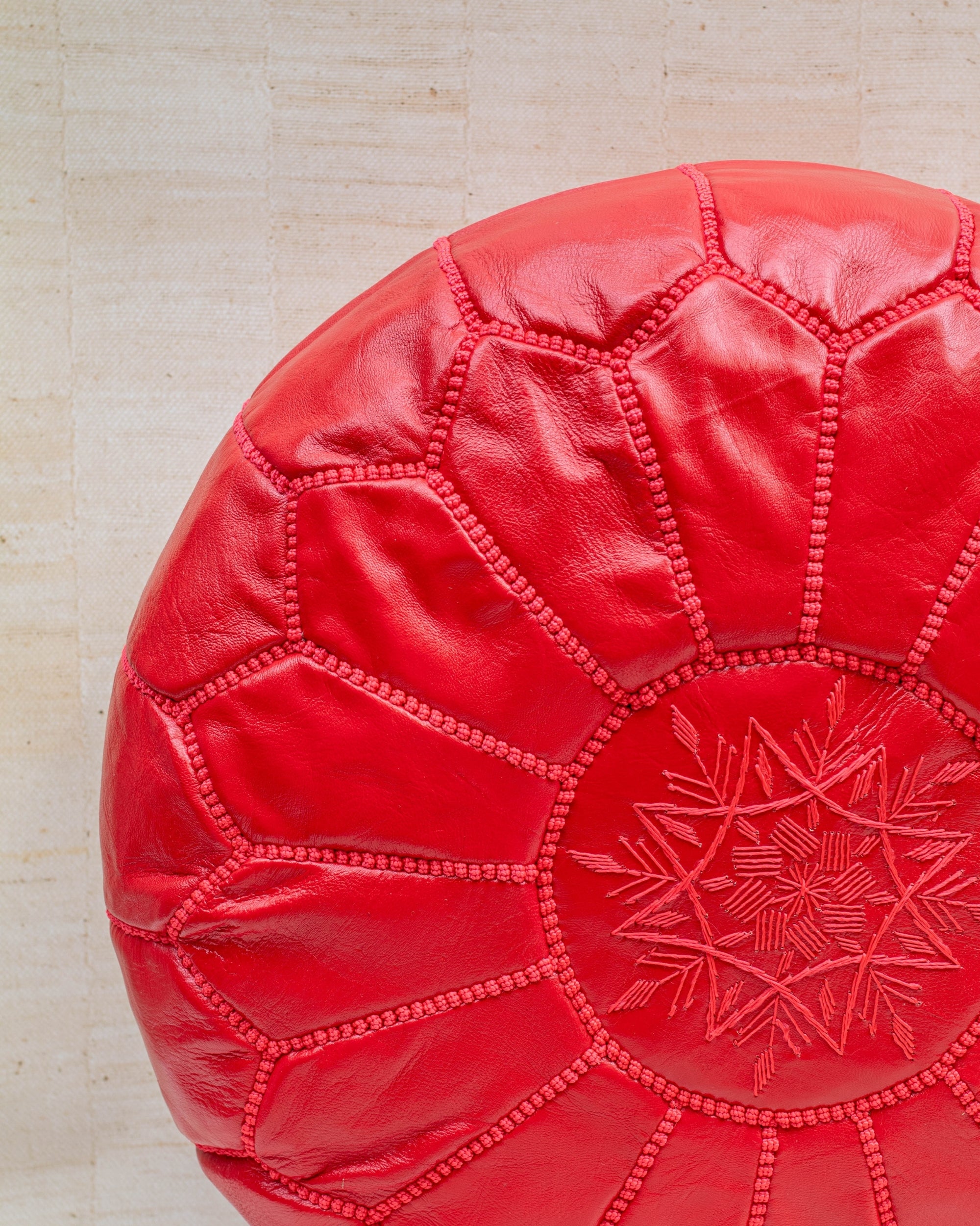 Red leather pouf – hand-stitch embroidery close-up