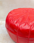 Red pouf styled in living room as ottoman