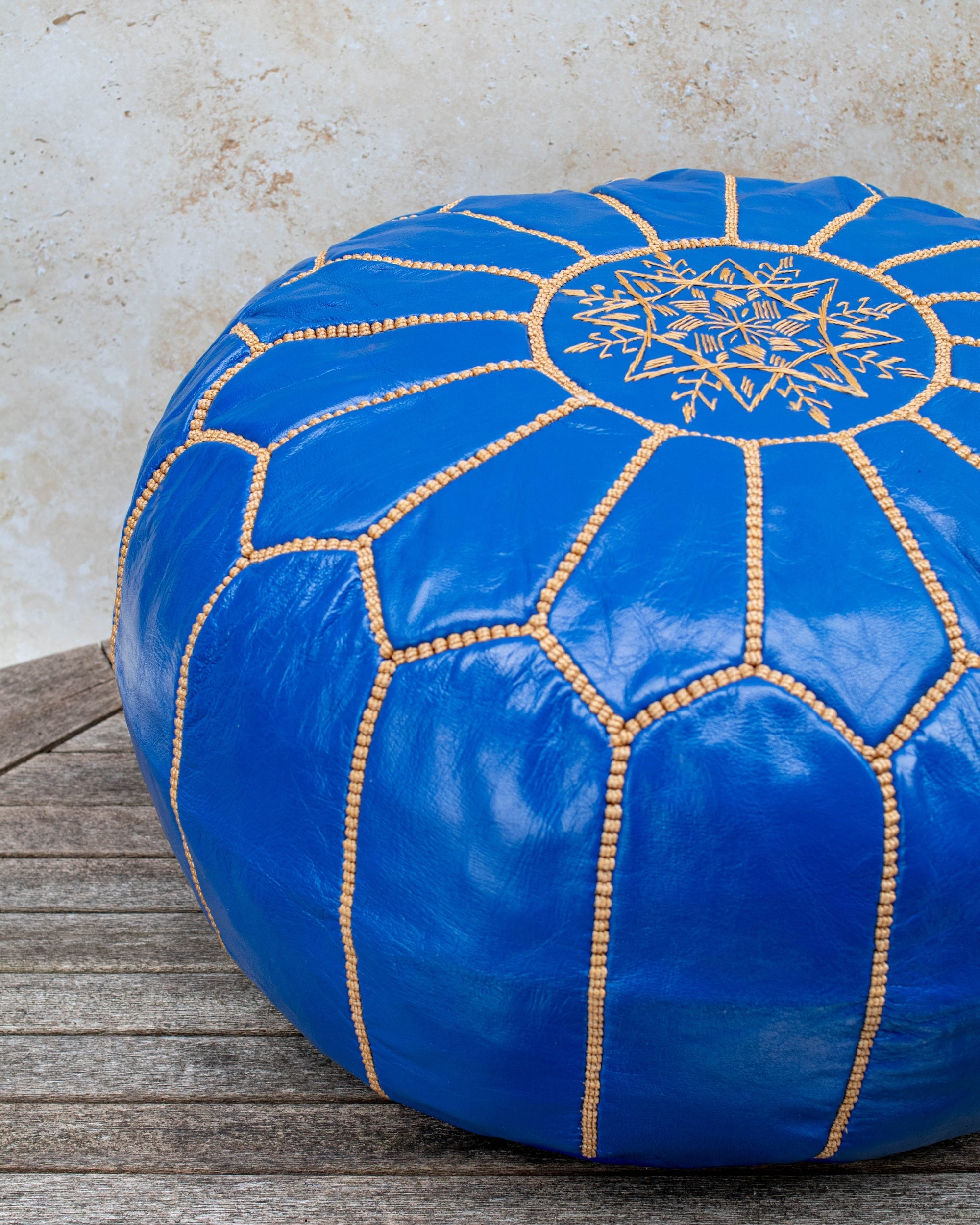 Royal blue pouf styled as ottoman in living room