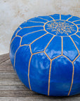 Royal blue pouf styled as ottoman in living room