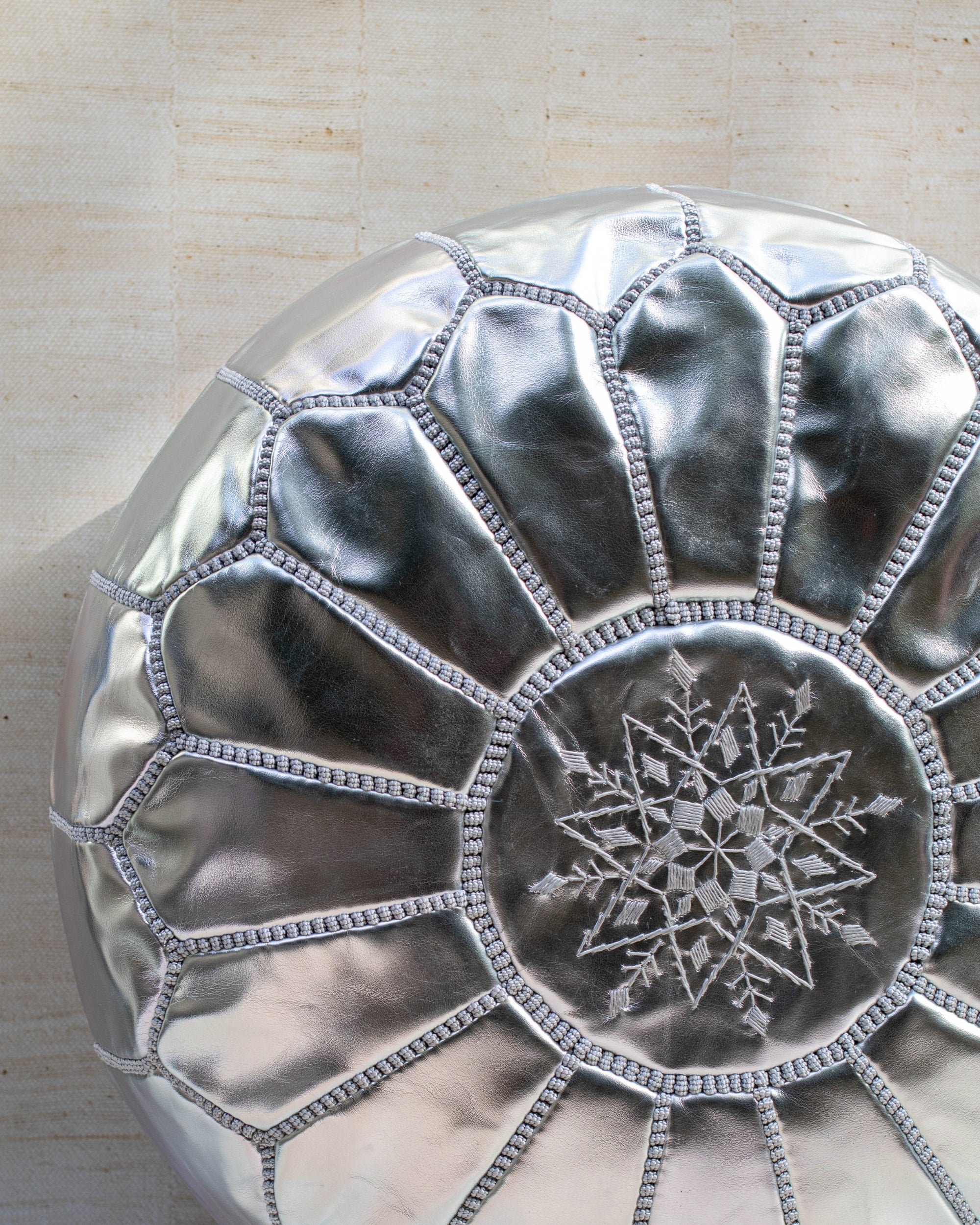 Silver pouf styled in living room as ottoman