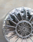 Silver pouf styled in living room as ottoman