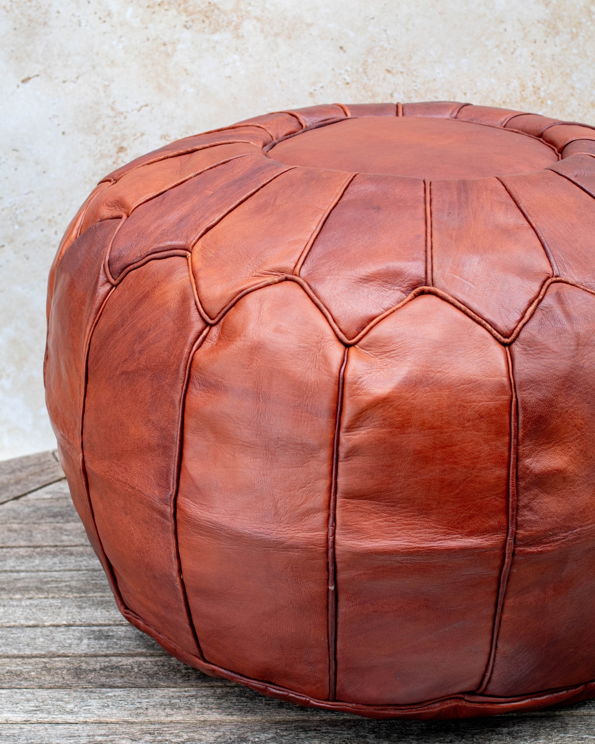 Tan Moroccan pouf styled as ottoman in living room