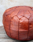 Tan Moroccan pouf styled as ottoman in living room