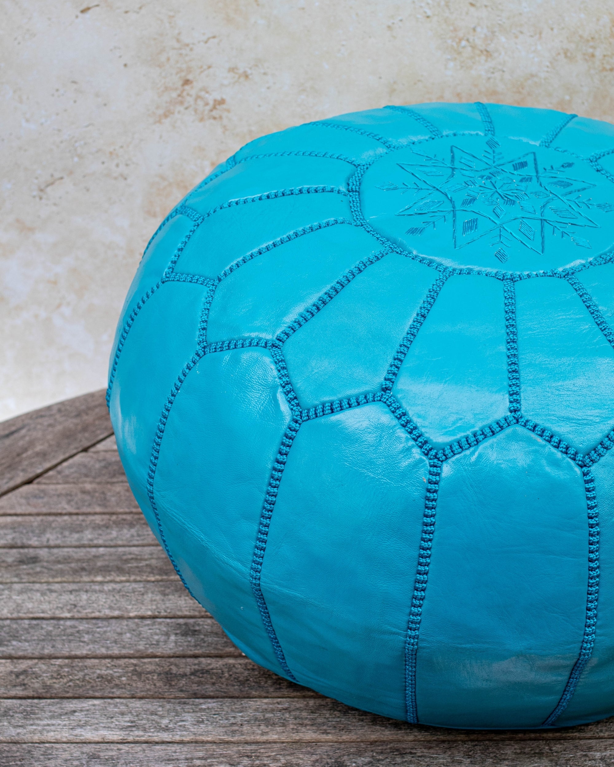 Teal pouf styled in living room as ottoman