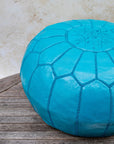 Teal pouf styled in living room as ottoman