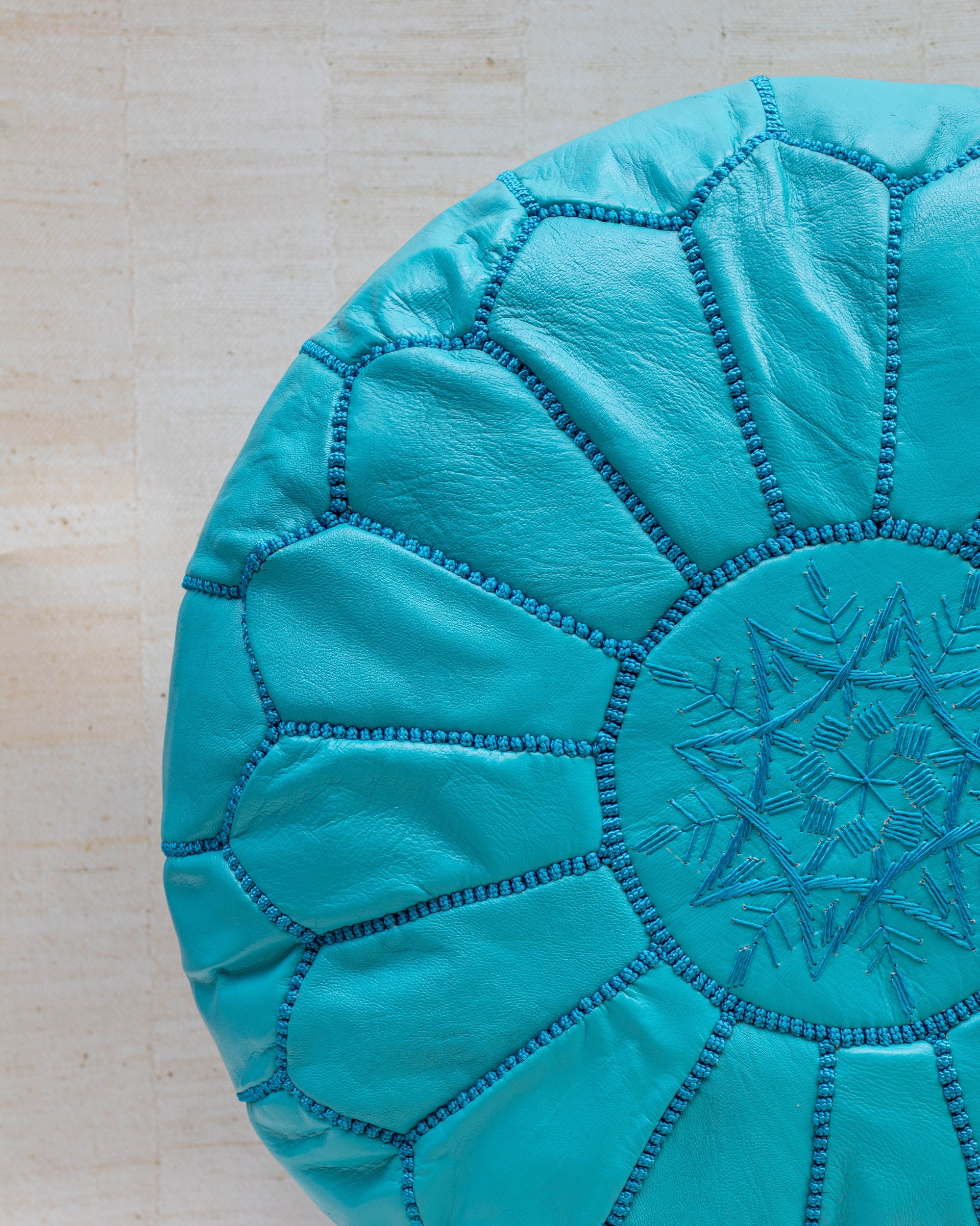 Turquoise leather pouf with hand-stitching – embroidery detail close-up