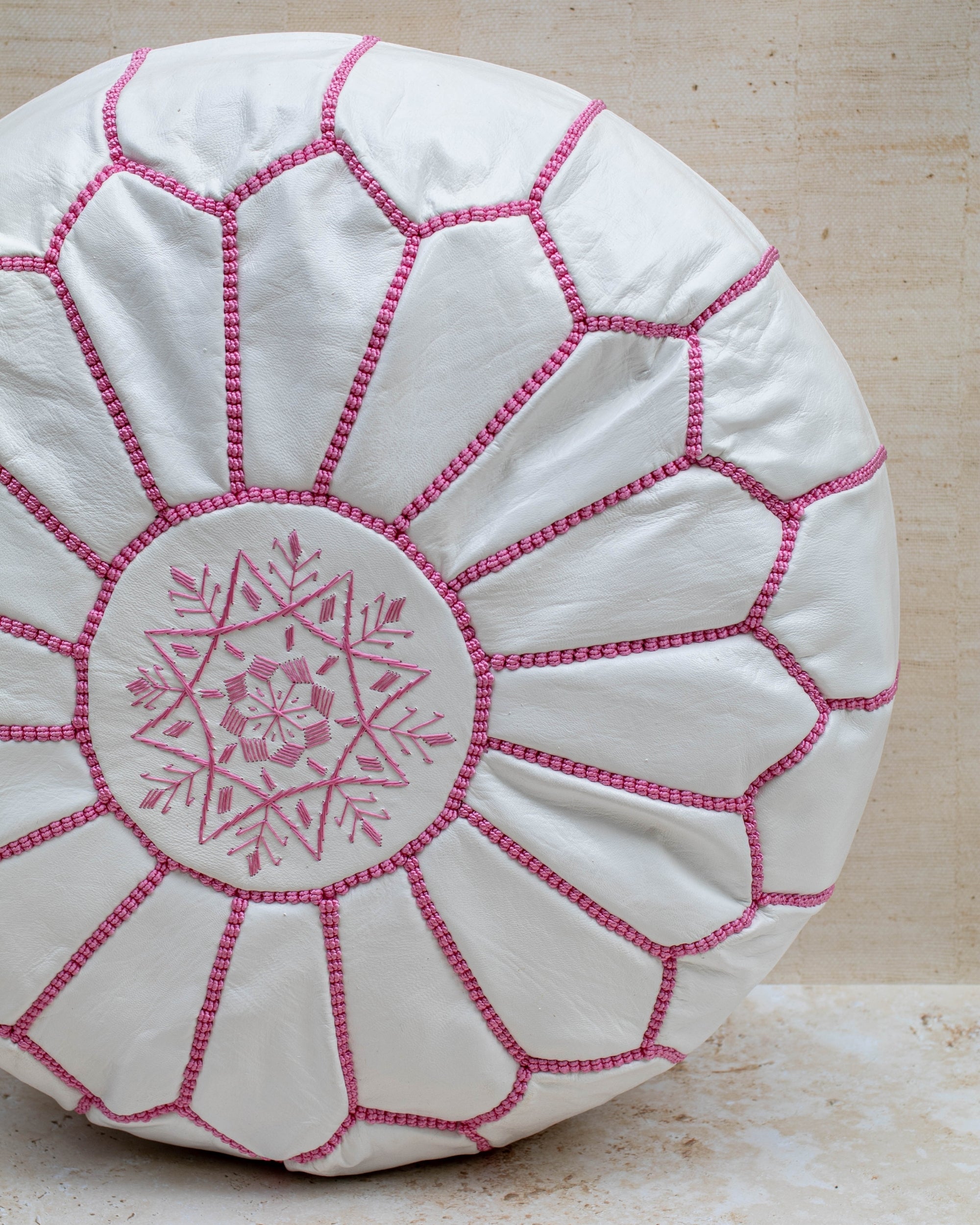 White leather pouf with pink hand-stitching – embroidery detail close-up