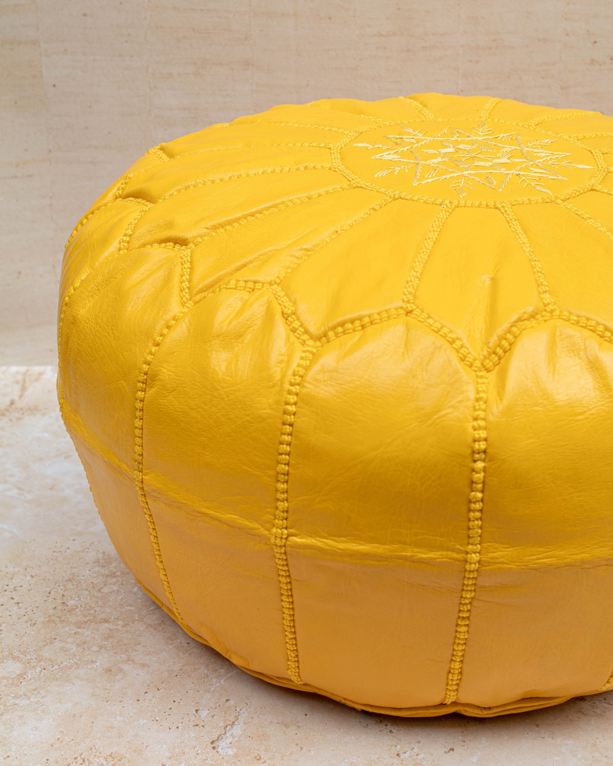 Yellow pouf styled in living room as ottoman