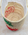 Palm leaf basket with green and red embroidery – close-up of stitching