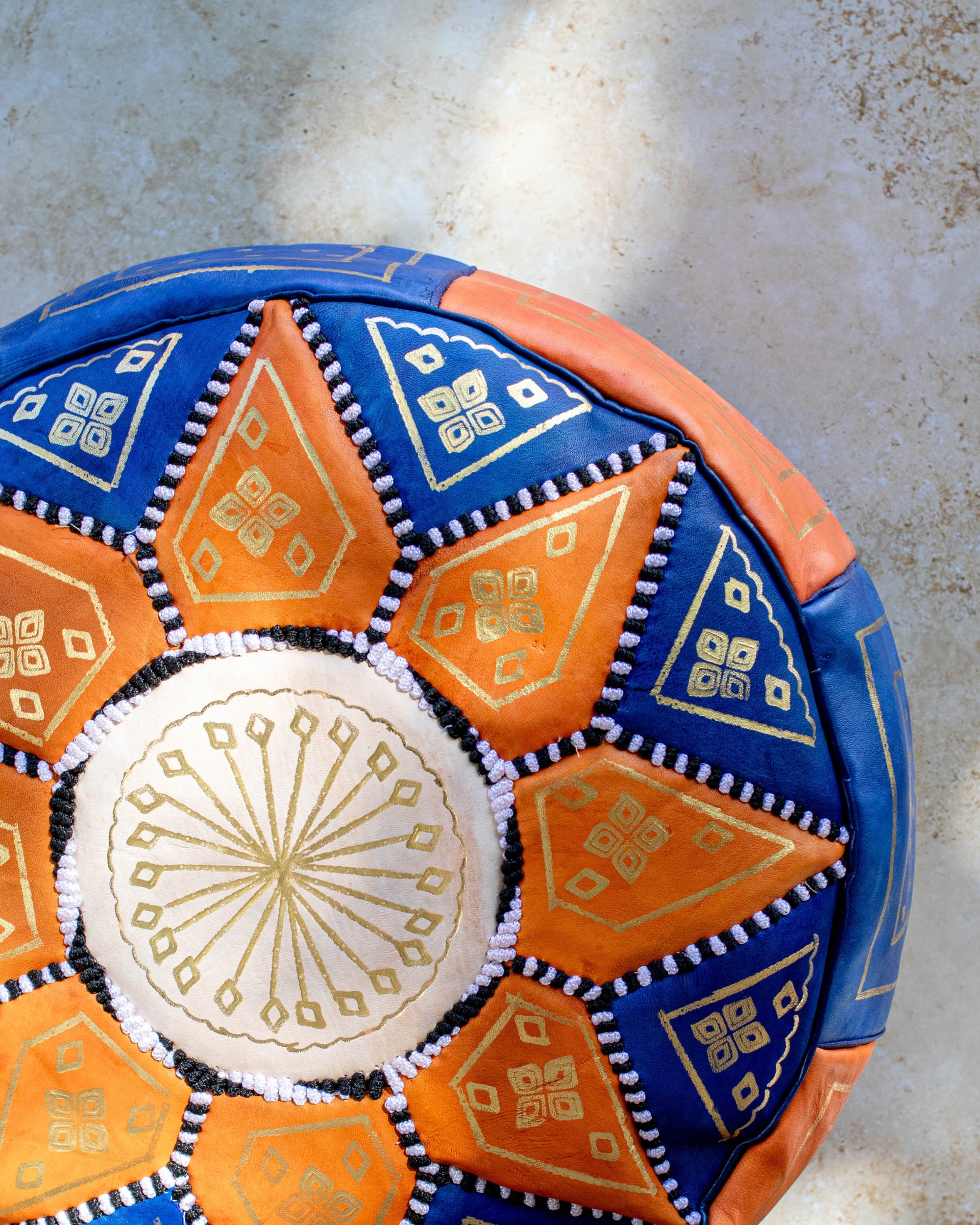 Moroccan leather pouf styled as ottoman in living room