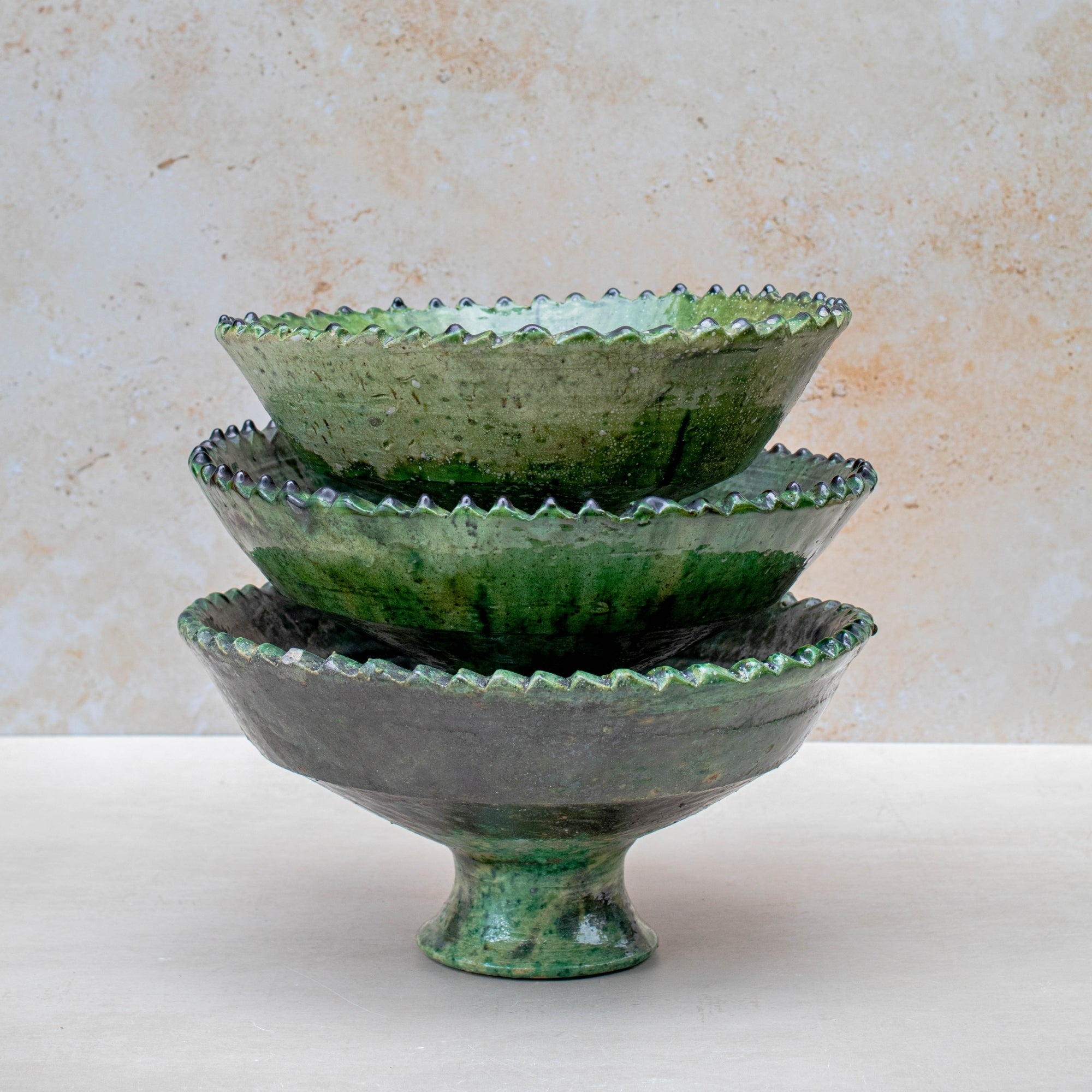 Authentic Tamegroute pottery bowl, handmade in the village of Tamegroute, southern Morocco. Every bowl is hand-thrown from local mineral-rich clay and finished with the village's signature deep green glaze. Fired in underground wood-fired kilns using centuries-old techniques, the heat creates natural variations in tone and texture across each piece. The glaze reacts organically to the kiln fire, producing distinctive emerald-to-moss tones with subtle bronze highlights. No two bowls are identical.
Perfect as