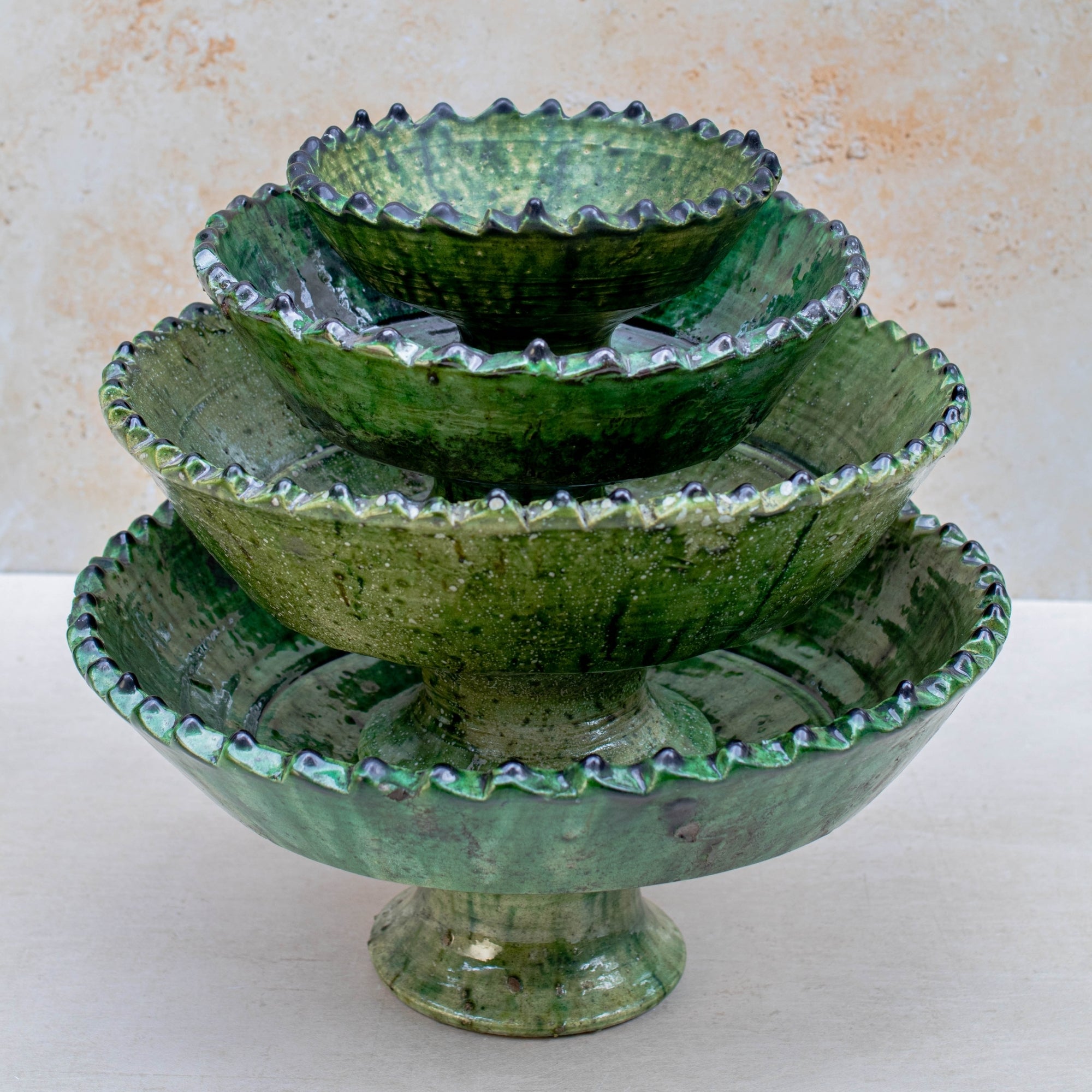 Authentic Tamegroute pottery bowl, handmade in the village of Tamegroute, southern Morocco. Every bowl is hand-thrown from local mineral-rich clay and finished with the village's signature deep green glaze. Fired in underground wood-fired kilns using centuries-old techniques, the heat creates natural variations in tone and texture across each piece. The glaze reacts organically to the kiln fire, producing distinctive emerald-to-moss tones with subtle bronze highlights. No two bowls are identical.
Perfect as
