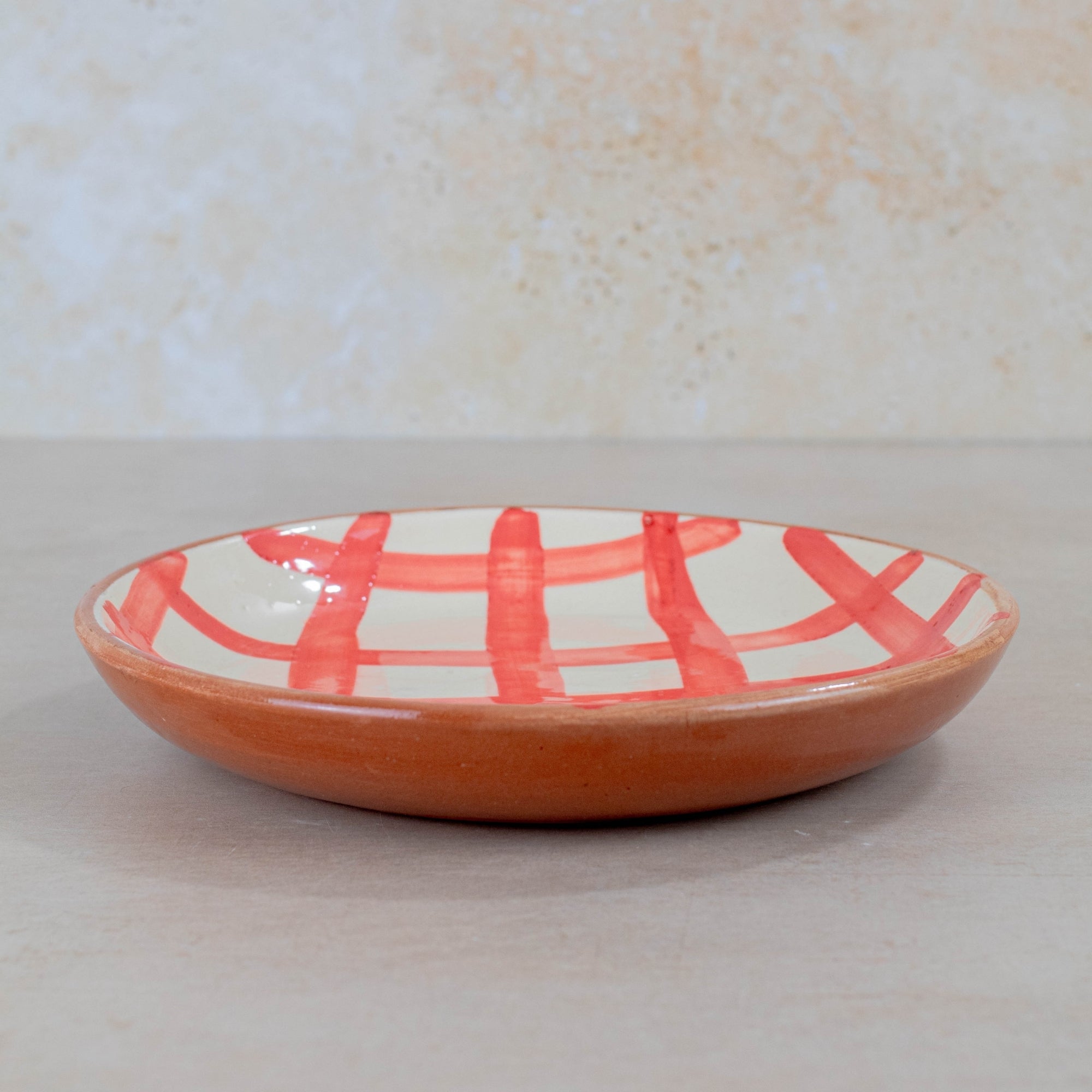 Ceramic plate with red abstract design on a white background