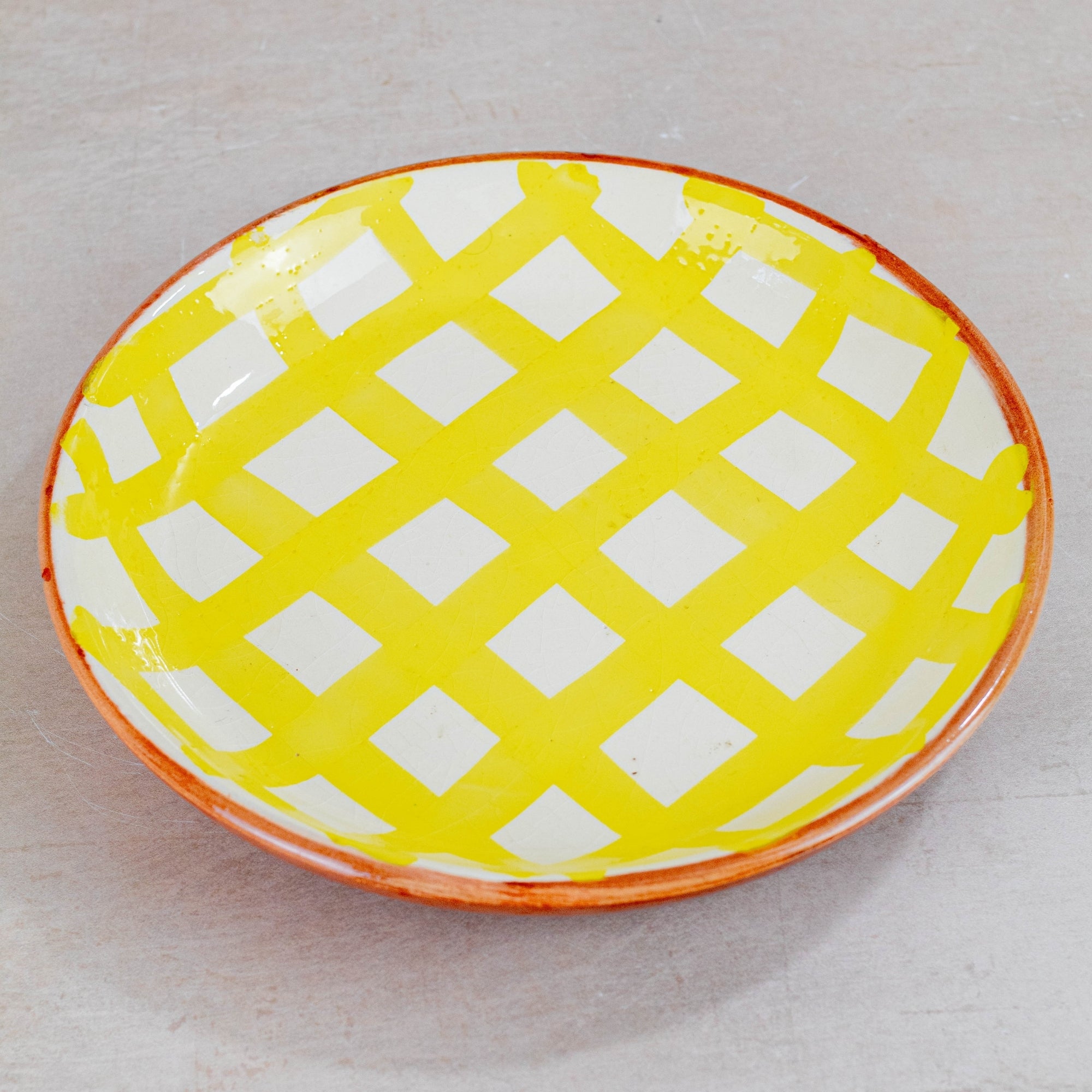 Yellow and white checkered plate on a light gray background